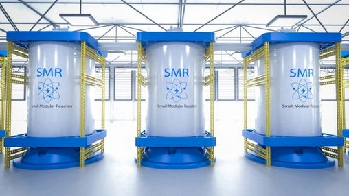 Three white cylindrical SMR units labelled Small Modular Reactor on blue mounting frames in a bright facility