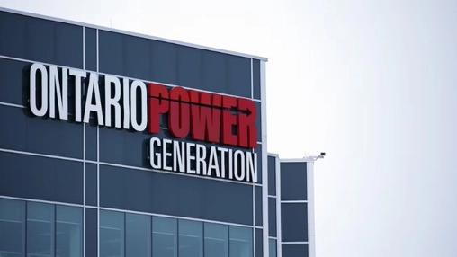 Low-angle view of Ontario Power Generation headquarters with large illuminated signage on a glass facade