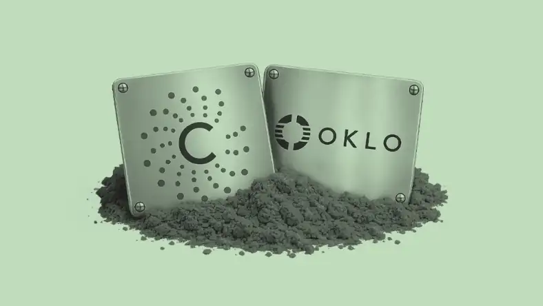 Two square metal plates with the Centrus and Oklo logos resting in grey powder on a green background